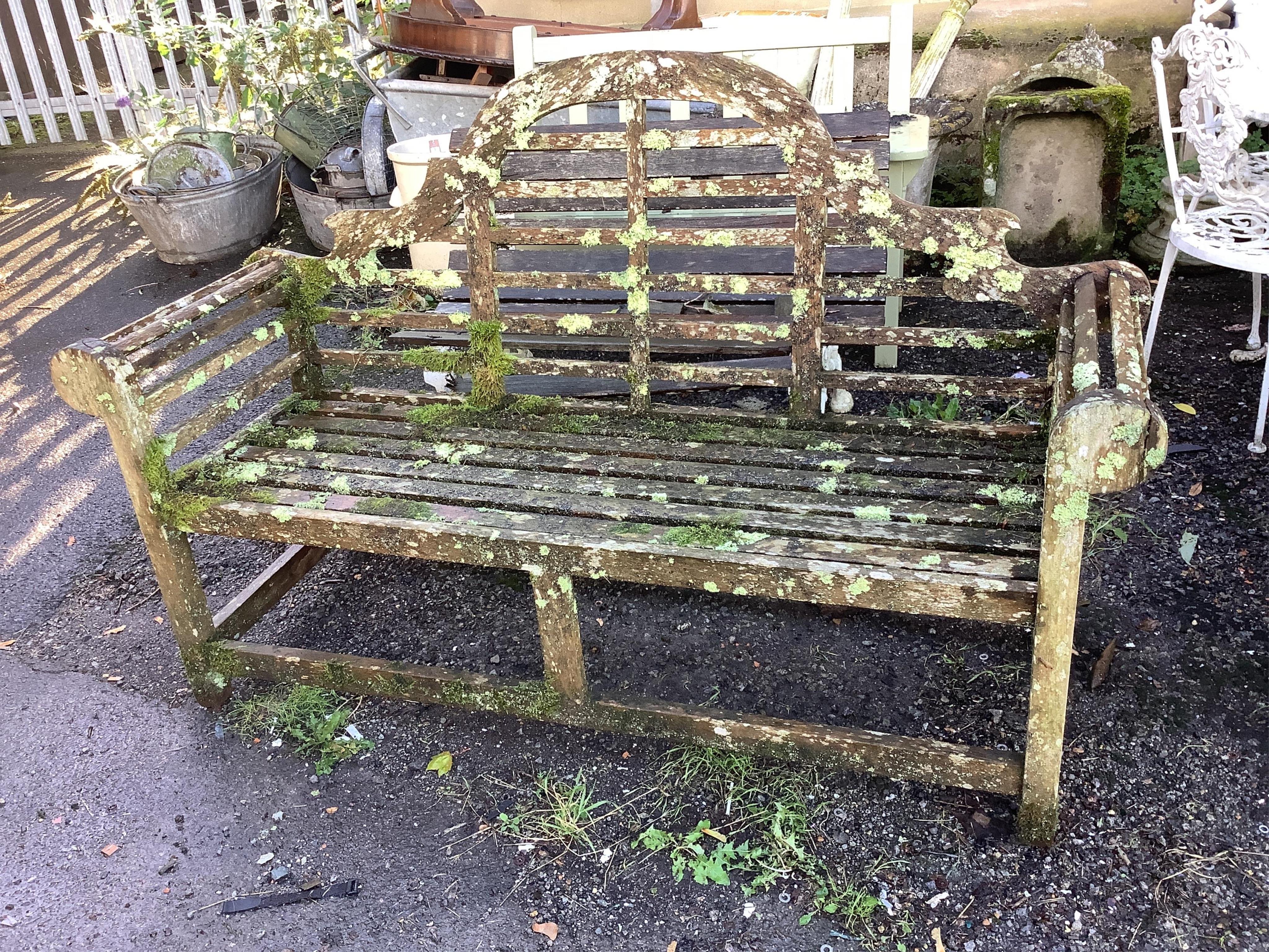 A weathered teak Lutyens style garden bench, width 165cm, depth 58cm, height 103cm. Condition - poor, covered in moss and lichen